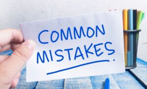 Person holding a note card that says “Common Mistakes” in bold blue letters.